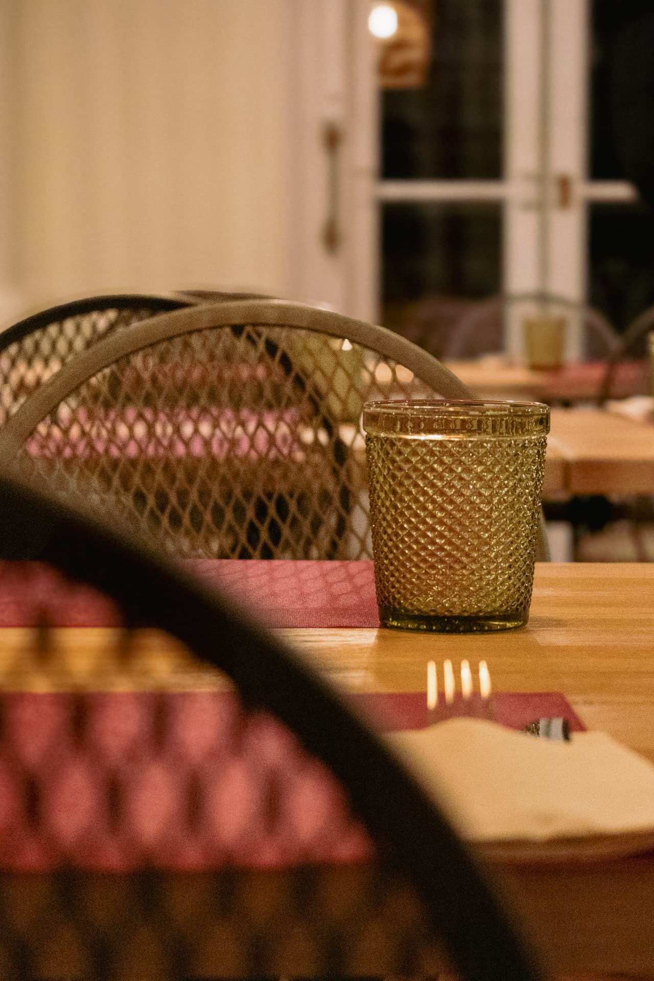 Silla de rejilla y vaso dorado sobre la mesa de Latitud Cero Sabadell