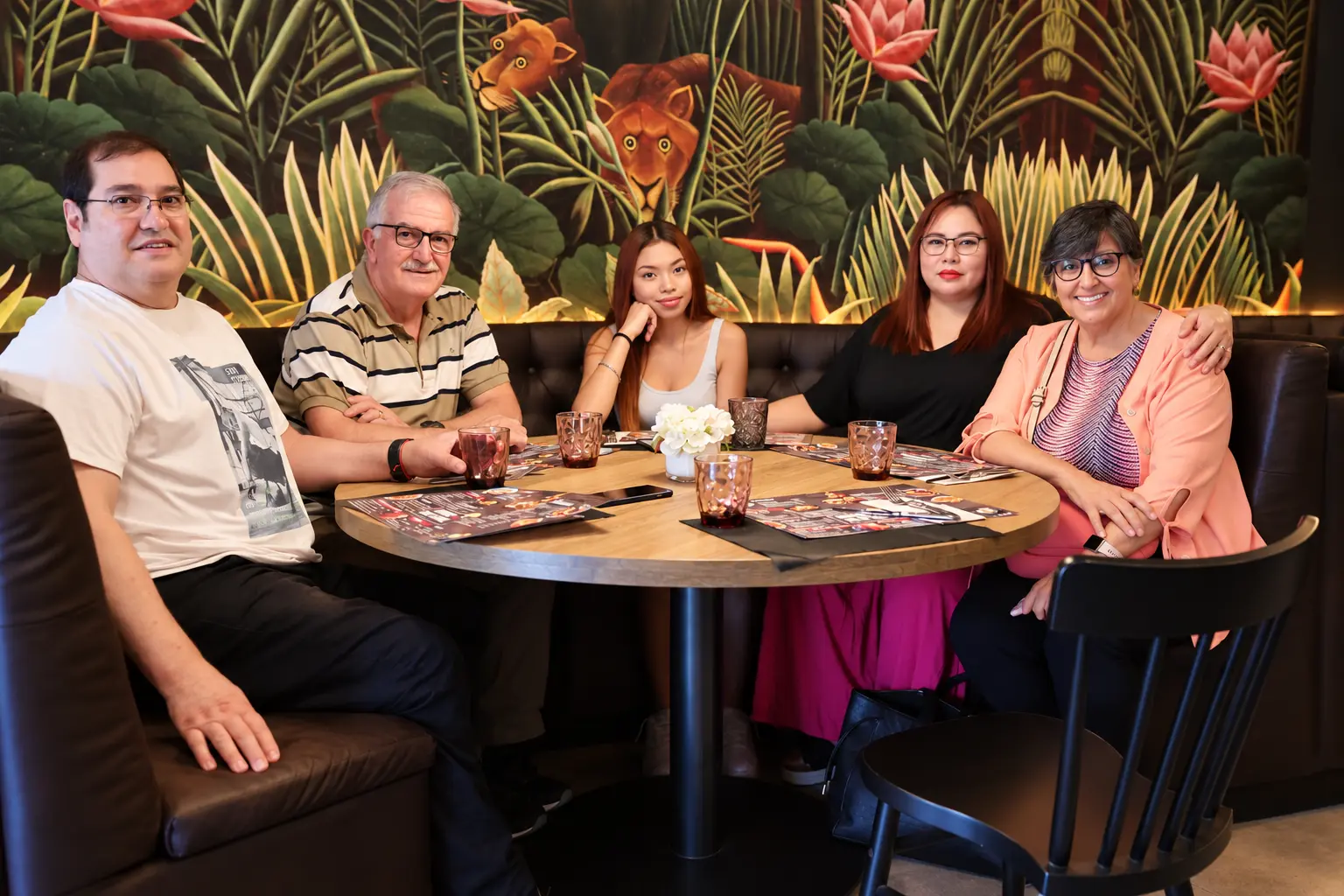 Clientes en una mesa redonda frente al mural botánico en Rubí