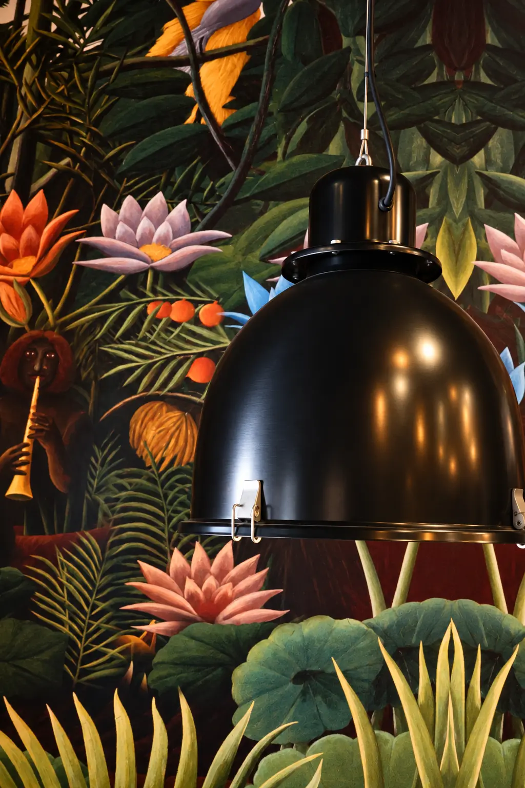 Lámpara negra sobre el mural floral en Latitud Cero Rubí