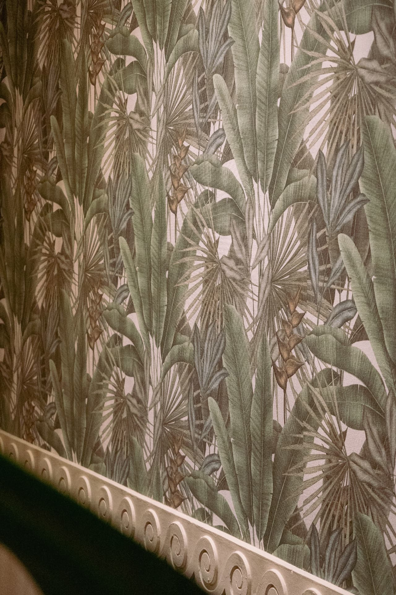 Mural tropical con hojas y palmeras en Latitud Cero Sabadell
