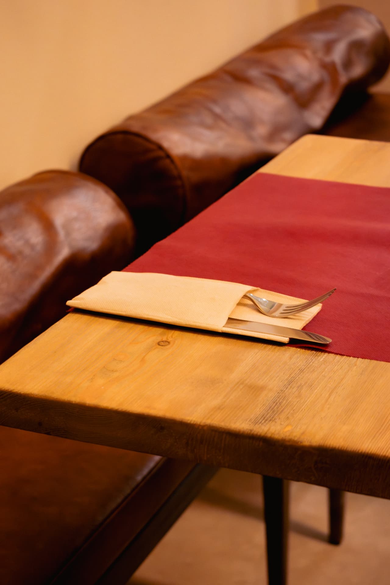 Mesa con cubiertos y sofá de cuero en Latitud Cero Sabadell