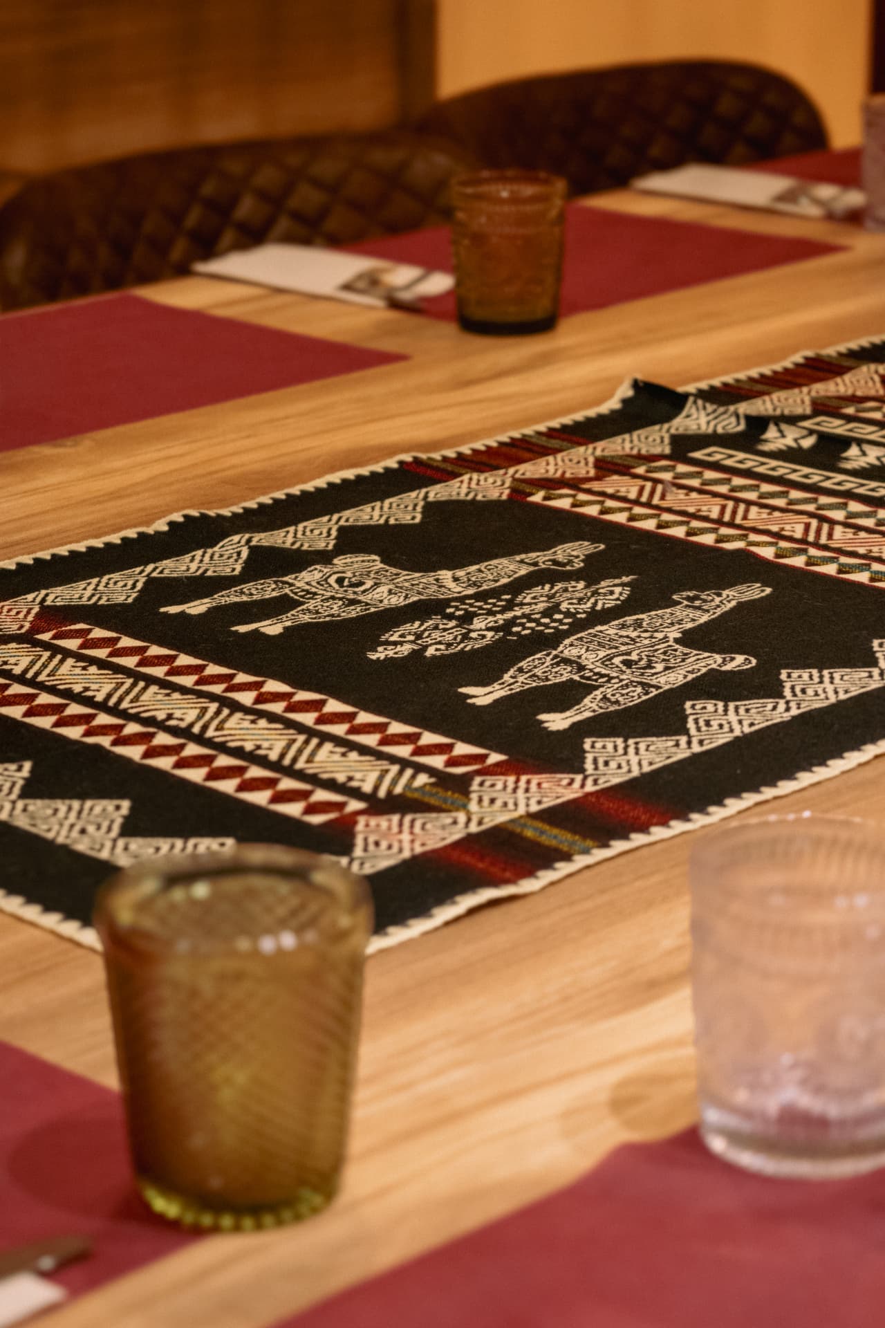 Detalle de mesa con camino andino y vasos en Latitud Cero Sabadell