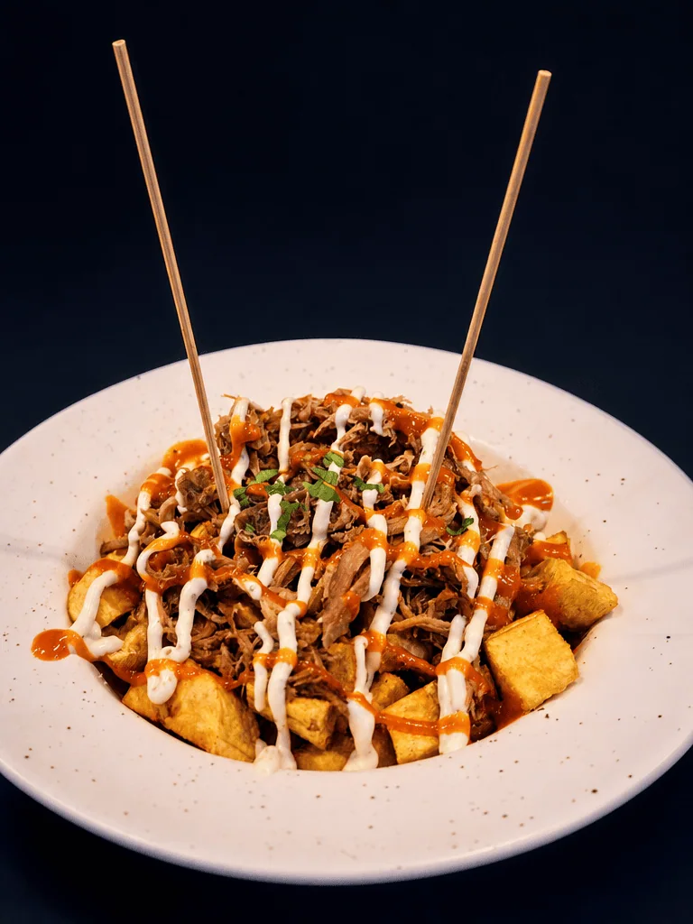 Bravas de plátano macho con hornado y salsa picante