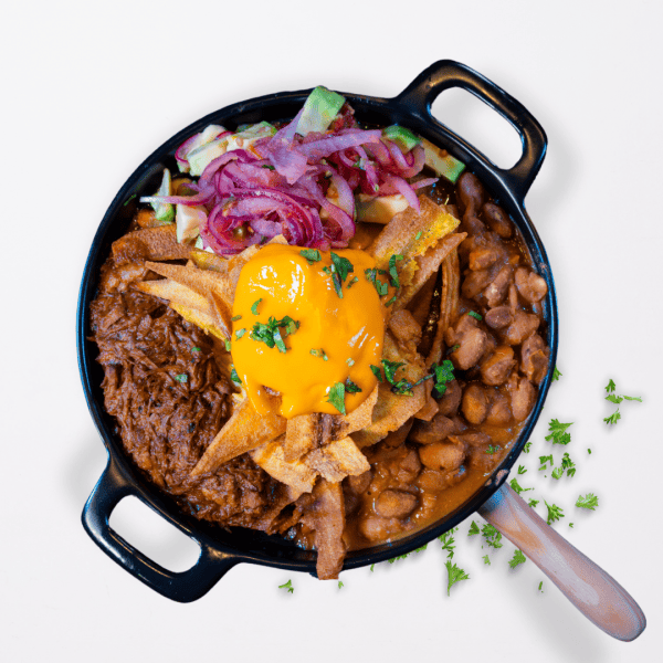 06 Juancho's (chips de plátano macho, carne mechada, frijoles, queso fundido y aguacate en salsa criolla)